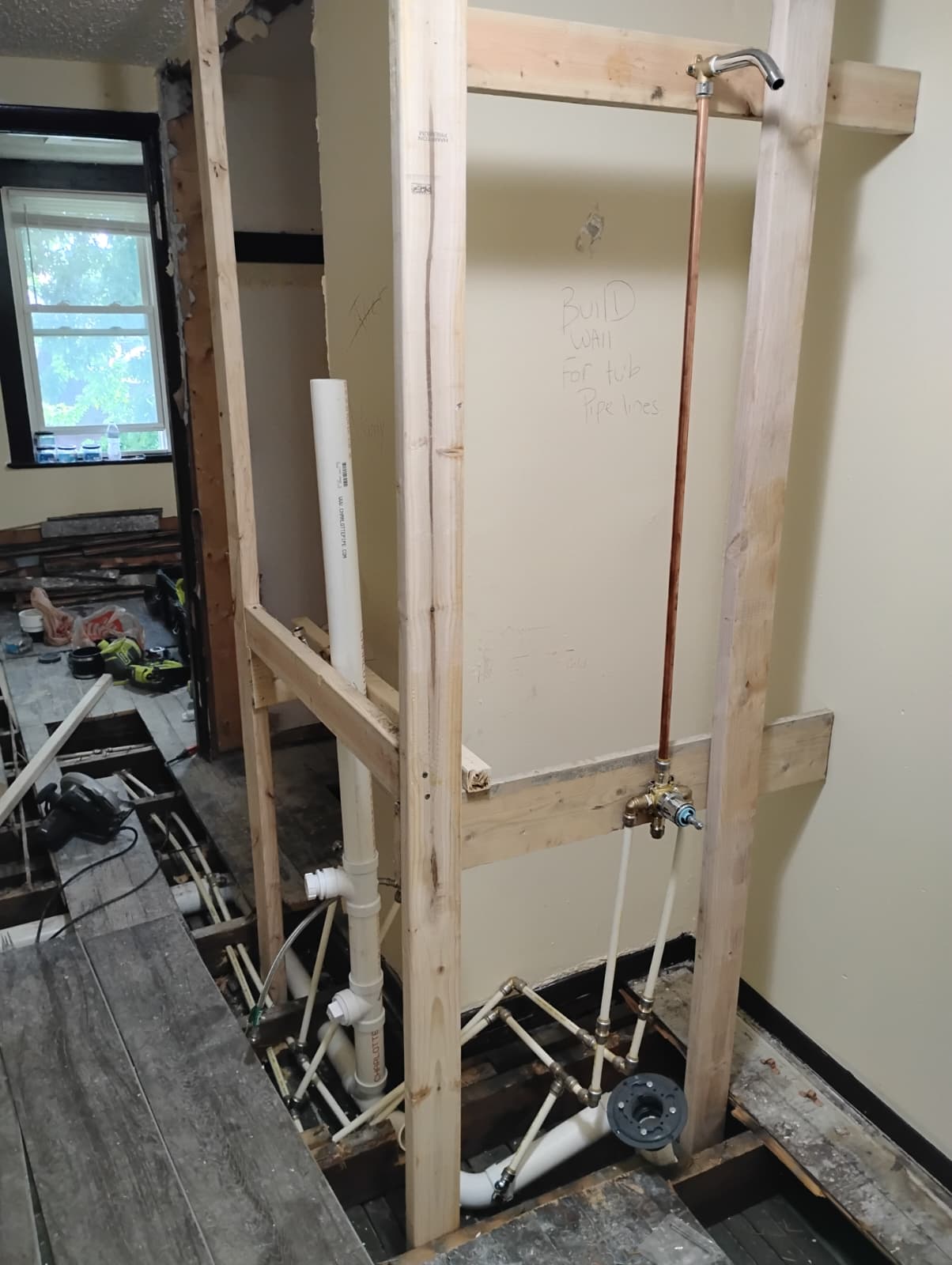 New tub wall framed with shower valve and copper riser installed