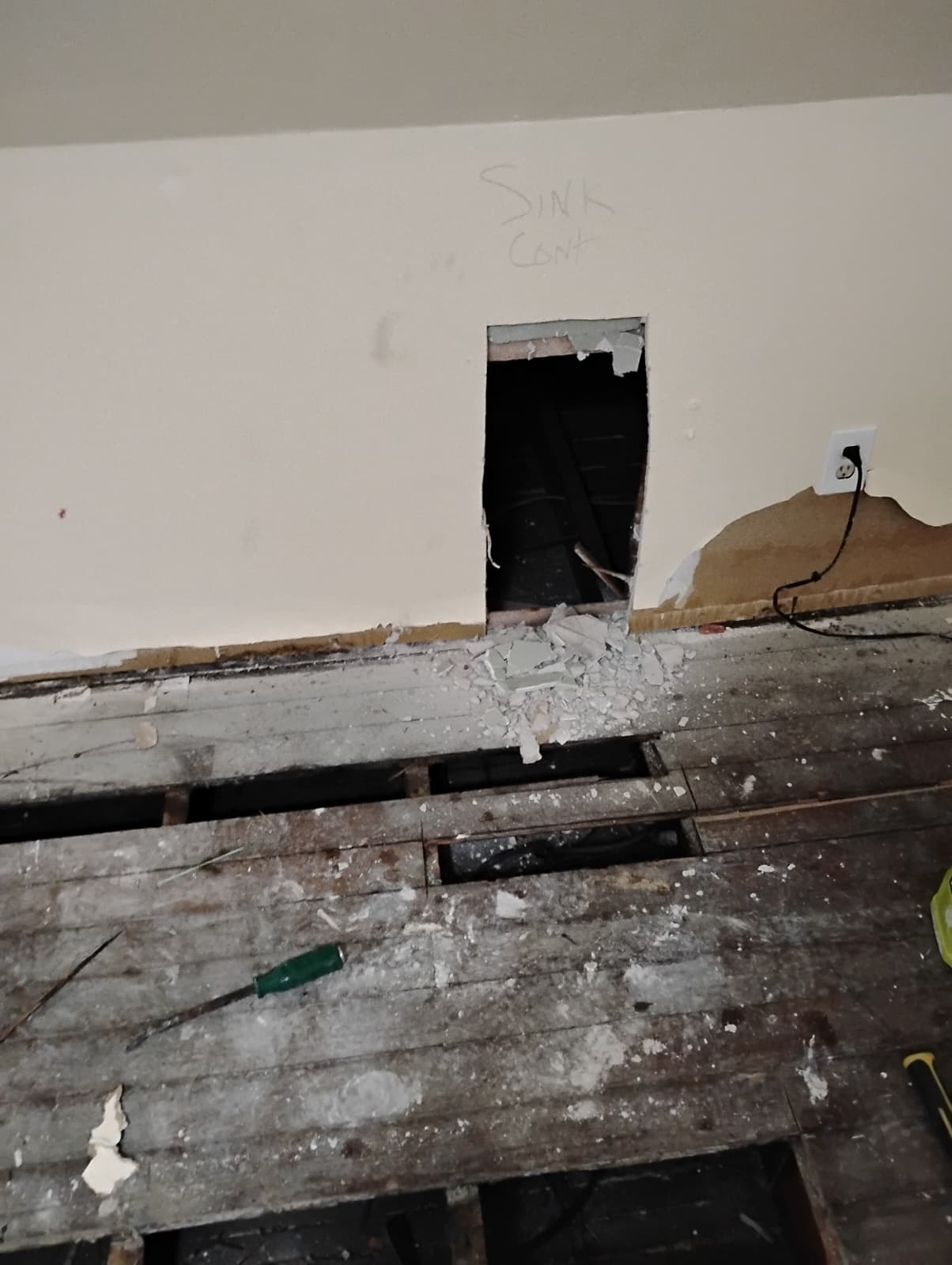 Floor opened along the wall for new plumbing runs